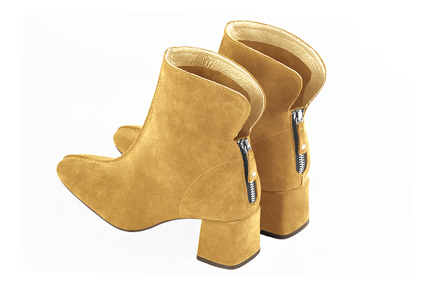 Mustard yellow women's ankle boots with a zip at the back. Square toe. Medium block heels. Rear view - Florence KOOIJMAN